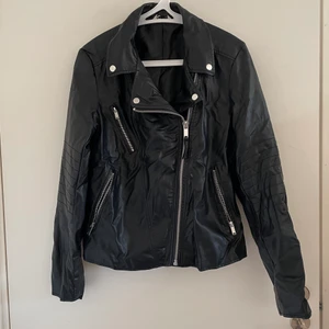 Skinnjacka skinnimitation 38 medium - Oanvänd, endast provad jacka i skinnimitation från Cubus. Endast skrynklig för den har legat vikt. Står storlek 40 men skulle uppskatta till storlek 38. Sitter bra på mig som är normal dam medium. Blir lite trång om jag har tjock stickad tröja under så skulle säga den sitter bra på en small också! 