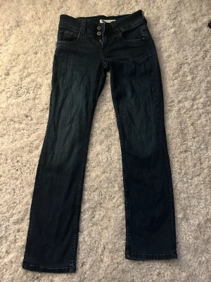 Mörkblå lågmidjade pepe jeans - Säljer mina super fina lågmidjade utsvängda jeans ifrån pepe jeans köpta på Sellpy. Dem är i mycket bra skick och super fin mörkblå färg.