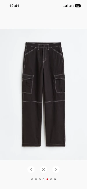 Svarta cargobyxor - Svarta cargo byxor med vita sömmar i storlek s använda en gång men ser ut som nya då jag inte känner att de är min stil pris kan diskuteras köpta för 249kr