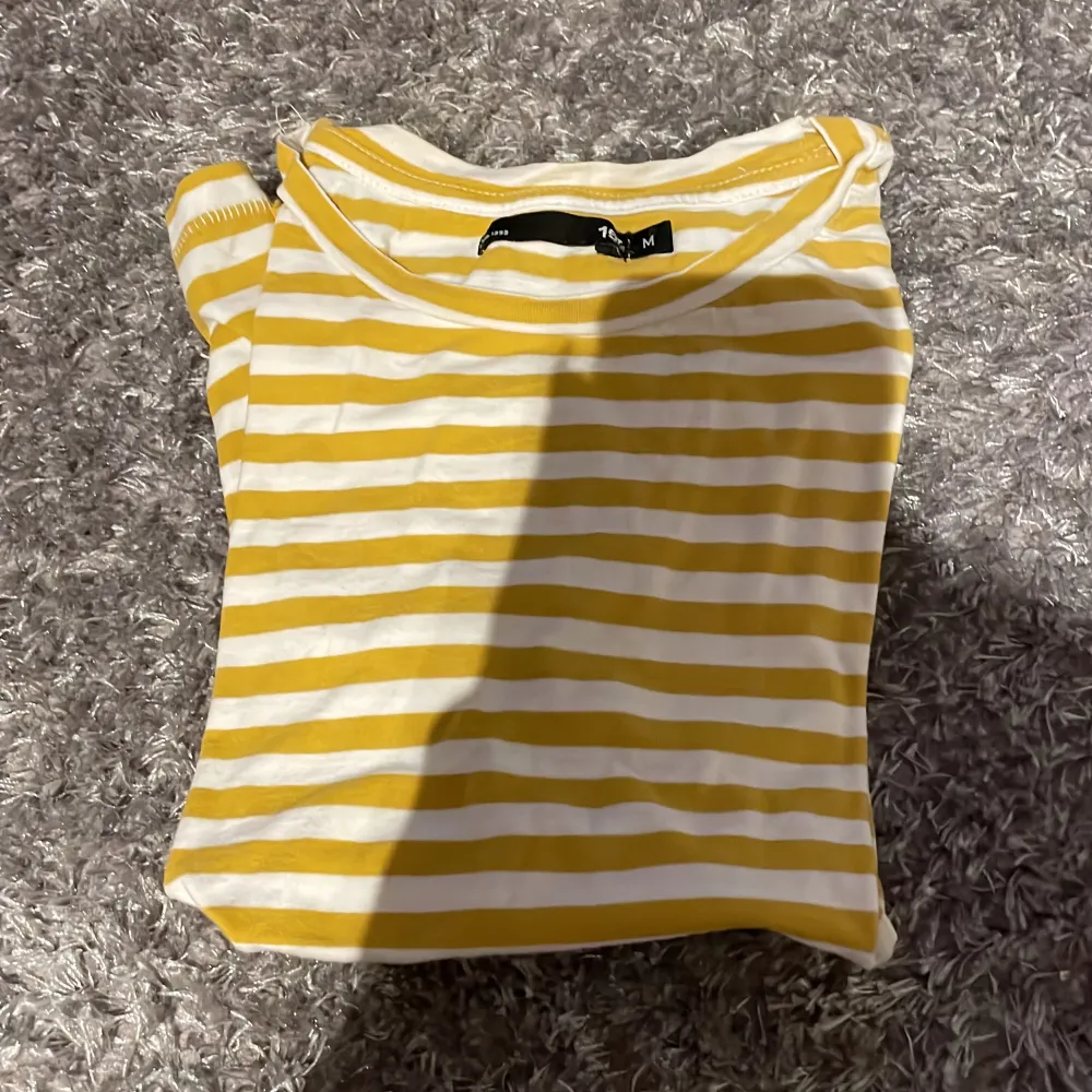 Detta är en randig t-shirt med gul och vita ränder och är från lager 157 och är i storlek m.. T-shirts.