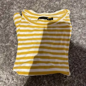 Detta är en randig t-shirt med gul och vita ränder och är från lager 157 och är i storlek m.