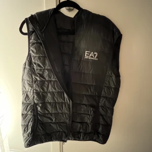 Armani Väst Med Huva - Äkta. Ganska använd. Bra kvalite. Har en huva. Pris kan diskuteras vid snabb och smidig affär.