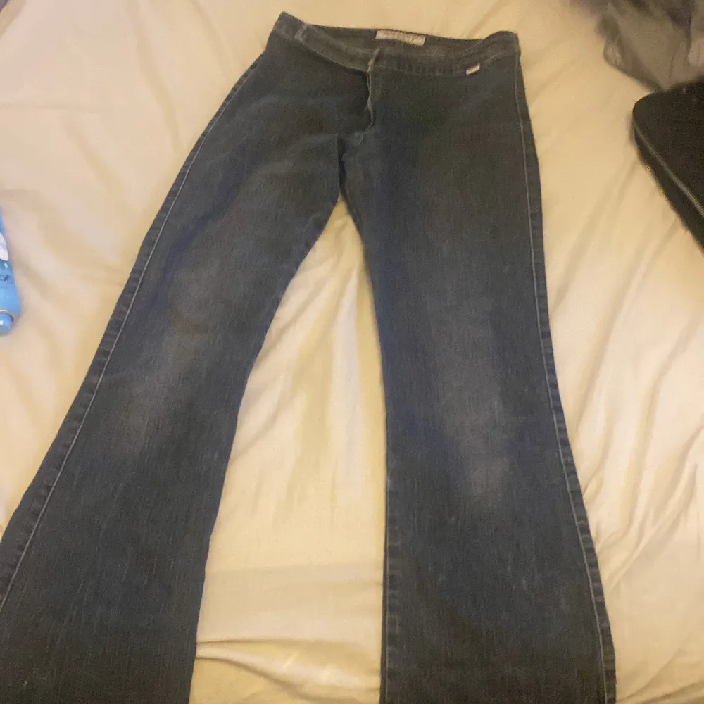 Ett par blåa flaered lågmidjade y2k byxor. Jeans & Byxor.