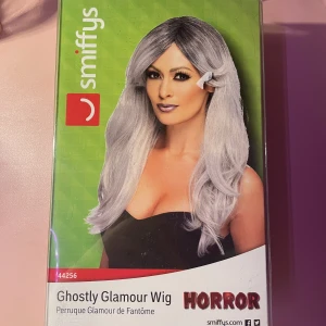 Grå peruk med lugg - Köptes från partyland några år sedan. Endast provad och aldrig använd. Kan skicka fler bilder om önskas.  