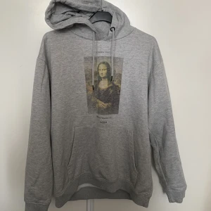 Hoodie med tryck, moona lisa  - Helt okej kvalite, har haft den ganska länge och den har en liten skada, men jag kan sy den innan jag skickar den t er