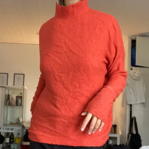 Stickad tröja - Orange stickad tröja, fin hostig färg med lös lite högre krage. Sticks inte, ull, nylon och akryl.