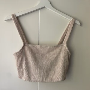 Festtopp - Beige topp från Zara i lite ribbat tyg! Klä upp till fest eller klä ner till en vanlig sommardag, superfin! Storlek S.