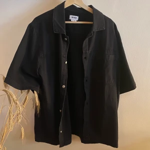 WEEKDAY SVART KORTARMAD SHORTA - Weekday kortarmad shorta. Använd 2 gånger. Size L. Pris 200