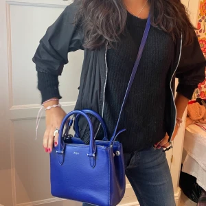 Blå Ralph Lauren väska💙🤍💙 - Snygg väska som man kan hålla i handtagen eller ha hängandes😆💖 Jättefint skick!  Kommer från Ralph lauren och köptes dyrt❤️