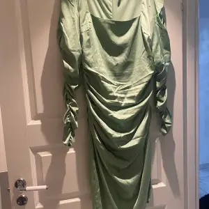En mintgrön silkes klänning som endast är använd en gång. Klänningen är i storlek 42 och den har en väldigt fin passform. 