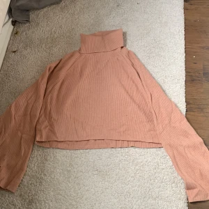 Rosa polotröja  - En fin rosa tröja med ett litet hål där nere på ärmen 