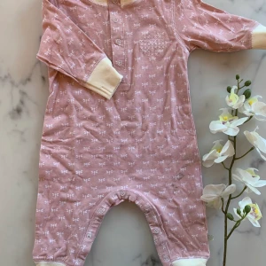 NY! Sparkdräkt rosa strl 62 - Ljusrosa sparkdräkt strl 62. Oanvänd men inga lappar kvar, tyvärr en fläck jag missade vid köp i butik, se bild 2. Går troligen bort i tvätt. Storlek 62. 