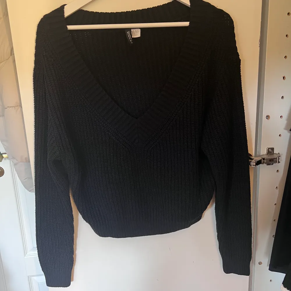 En svart stickad tröja med v-ringning från H&M i storlek S. Lite kortare i modellen, använd ett fåtal gånger. Tröjor & Koftor.