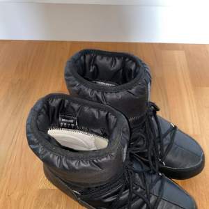 Ett par svarta moon boots i stl 39. Nästan helt oanvända och i väldigt fint skick! Dock ett litet färgavskrap på vänster sko nere vid sulan (se bild), syns inte när skon är på och påverkar inte funktionen. Vattentäta. Nypris: 1900 Frakt: 66 kr 