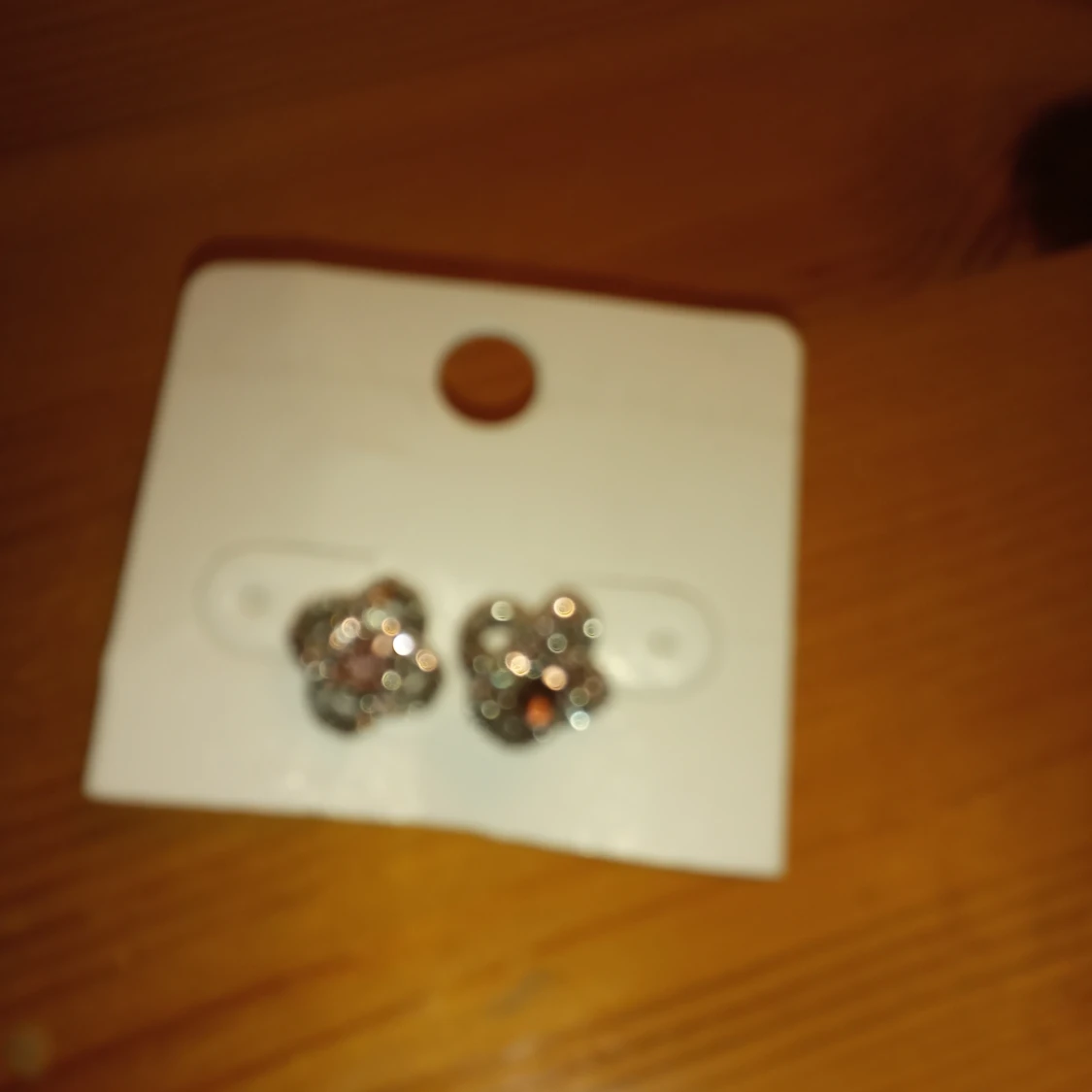 Örhängen med lila kristall i mitten samt flera små vita .