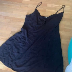 Svart klänning med knyte  - Svart klänning med knyte vid bröstet, inte stretchig alls 