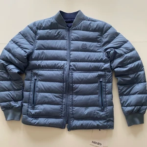 KENZO JACKA STORLEK L (passar M) - Sällsynt Lightweight Packable Jacket Kenzo. Nyskick, har aldrig använts. Jackan kan vändas ut och in vilket fungerar som att man får två jackor i en. En mörkblå och en ljusblå. Orginalpriset varierar mellan 2500 - 5000 sek.