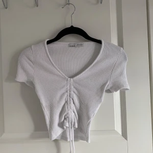 Croppad top  - Croppad vit top från pull&bear med snöre i mitten som man kan ”dra åt”. Svin snygg men aldrig använd💞