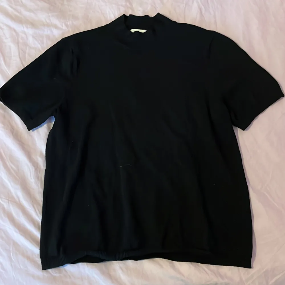 En svart stickad t-shirt med lite högre krage och lite längre ärmar, från H&M Basics i strl L. Basic men väldigt fin till ett par jeans eller vad som. . T-shirts.