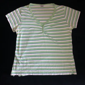 Randig topp med knappar - Grön-vitrandig topp med knappar. Bra skick. Skulle säga att den sitter som en M.