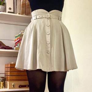 En väldigt söt kjol från märket Cartoon. Är beigegrå i färgen. Kommer med tillhörande skärp. Är i bra skick. Möts i Uppsala eller postar💕