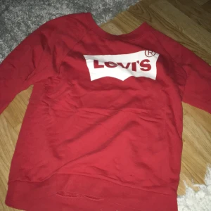 Levis  - En röd Levis tröja, bra skick men ett litet hål i ena ärmen, äkta. Säljs pga inte min stil och kommer ej till användning. Andvänd ganska mycket men inga fläckar förutom ett hål. Köparen står för frakten och tvättas såklart innan den säljs 