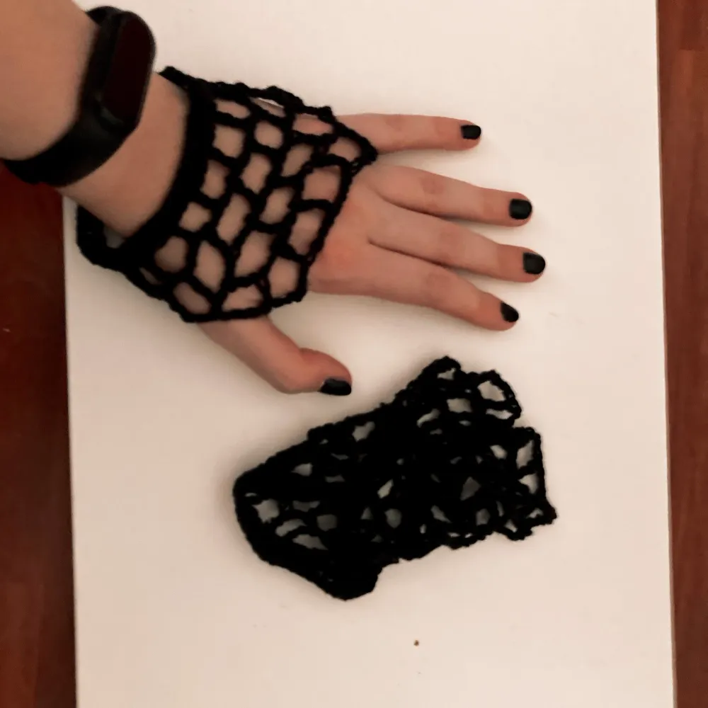 Black crocheted fishnet mitts. Stickat.