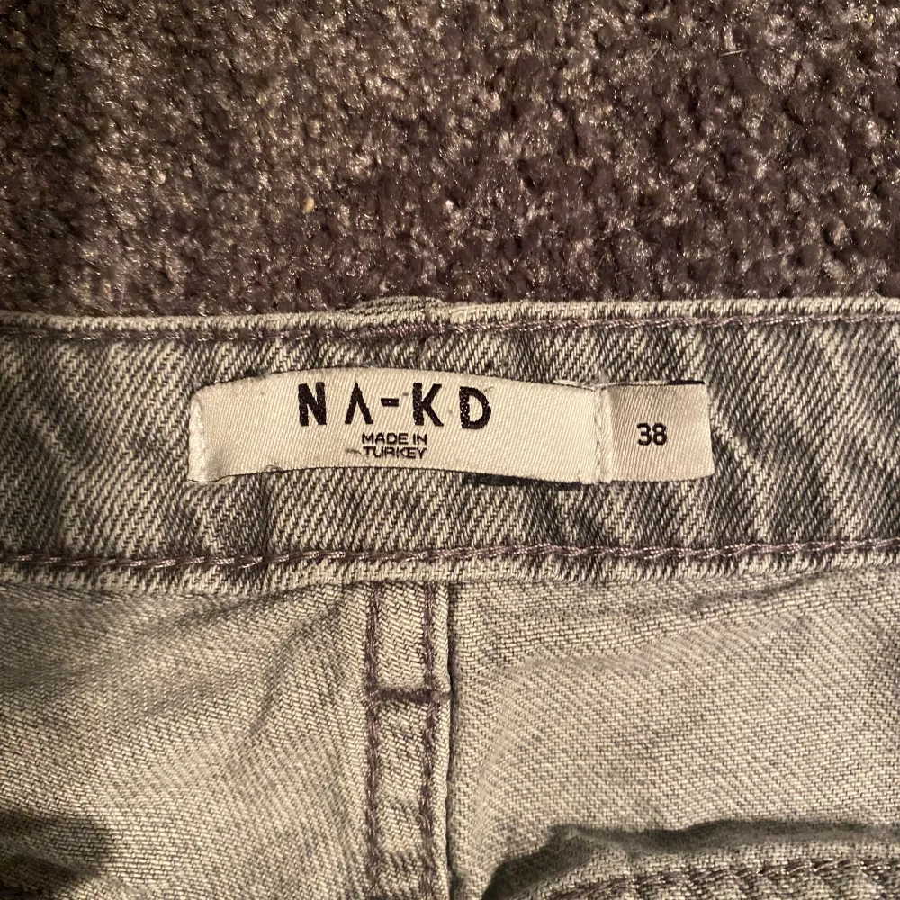 Gråa Lågmidjade jeans från NA-KD. Har en slits längst ner vid foten. Är 170 o dem är lagom för mig i längden. Säljer då de är för stora för mig. Har normalt 36-38 i byxor så skulle säga att dessa är lite stora i storleken🥰 då d. Jeans & Byxor.