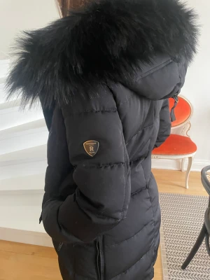 Super varm jacka  Rock and Blue modell Raven - Storlek 36 (S)  Nyskick inte använd! (S). En varm och snygg dunjacka med avtagbar päls.  en har en spänntamp i midjan, vilken man justerar från insidan. Jackan har två innerfickor, en på varje sida, placerade lodrätt i framkanten och vilka man stänger med