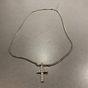 Jättefint halsband med ett kors och glittriga stenar. Helt nytt aldrig använt och inga defekter. Säljes pga att jag har ett liknande
