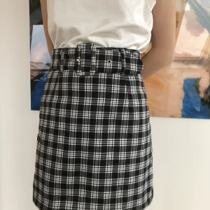 Rutig minikjol - Fodrad med bälte. Välbevarad I polyester och elastan