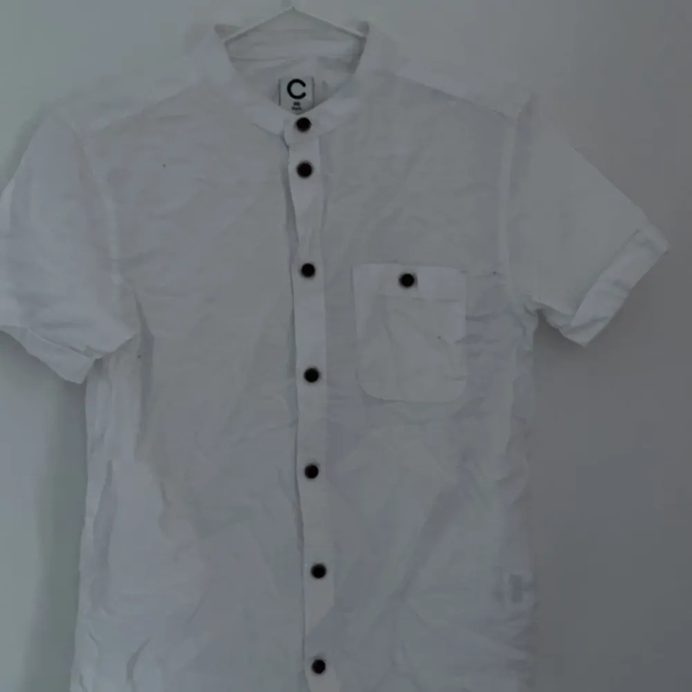 En vit kortärmad skjorta, endast använd en gång på en skolavslutning jätte bra skick och bruna knappar. I storlek 146, 11 år . Skjortor.