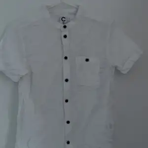 En vit kortärmad skjorta, endast använd en gång på en skolavslutning jätte bra skick och bruna knappar. I storlek 146, 11 år 
