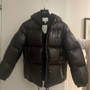 Svart dunjacka - Den jättesnygga helt slutsålda pufferjackan från H&M. Den är svart och lite glansig. Jätteskön men tyvärr beställde jag fel storlek! Aldrig använd!! Lappen e kvar o allt så den är sprillans ny 🙏🏼❤️