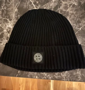 Stone Island mössa - Fin mössa från Stone Island, stlk junior 3 men stor i storleken och passar även vuxen. Jättebra skick, endast testad någon enstaka gång.  Finns i vallda eller kan skickas mot porto.  