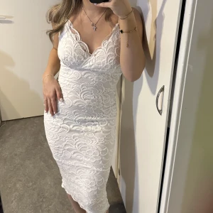 Vit tajt kläning med spets - Vit längre kläning med spets. Passar till Studenten!  Använd en gång! 