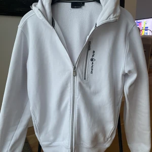 Sail Racing Bowman Zip - Garderobrensning! Säljer denna vita zip hoodie från Sail Racing. Stl M Cond: 9/10 I princip nyskick men tvättad några gånger. Inte använd mycket alls. Bara att skriva om det är något som undras! 