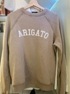 Arigato sweatshirt  - Köpt för 1 år sedan knappt Andvänd. Väldigt bra skick. Säljer för att den ej passar mig i storlek. Inga skador eller liknande på tröjan. Nypris 1500 