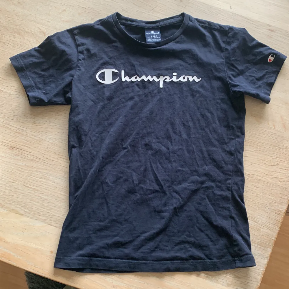 En mörkblå champion t shirt för 11/12 . T-shirts.