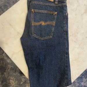 Nudie ”gritty jackson” 30/34 (endast testade) - Hej!   Säljer ett par jeans som endast är testade men var fel storlek, Alltså i absolut nyskick.   Storlek: 30/34 Modell: Nudie ”Gritty Jackson”  Färg: dark space  Pris: 500kr  Länk till jeans:  https://www.nudiejeans.com/product/gritty-jackson-dark-space