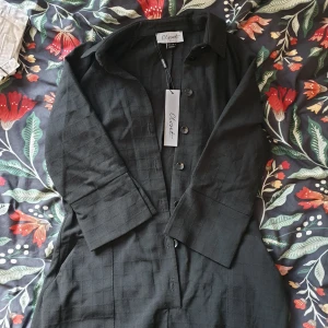 Svart byxdress, ny - säljer en jättegullig svart byxdress. den har väldigt somrig vibe, trekvartsärm och trekvartsben och flowy, tunt skönt tyg utan att sitta pösigt 🌻🌻 aldrig använd, lapp kvar! fickorna sticker ut lite just på spegelbilden men är inget som syns annars 😌