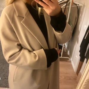 Beige kappa - En beige lång höst/ vår kappa frpn Hm. Väldigt fin och bra längd, endast en liten fläck längre ner på kappan som förmodligen går att tvätta bort 💕hör av er för frågor eller fler bilder!