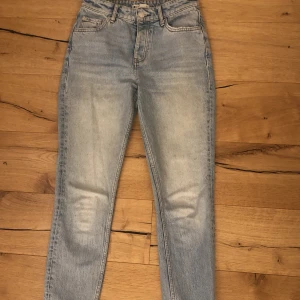 Blåa Jeans - Ett par blåa högmidjadejeans. Formar sig väldigt fint efter kroppen. Fint skick men använt de mycket. Sitter tyvärr lite för tajt i min midja och runt mina lår därför måste jag sälja dem. Köpta för 599 kr, säljer för 250 kr. 