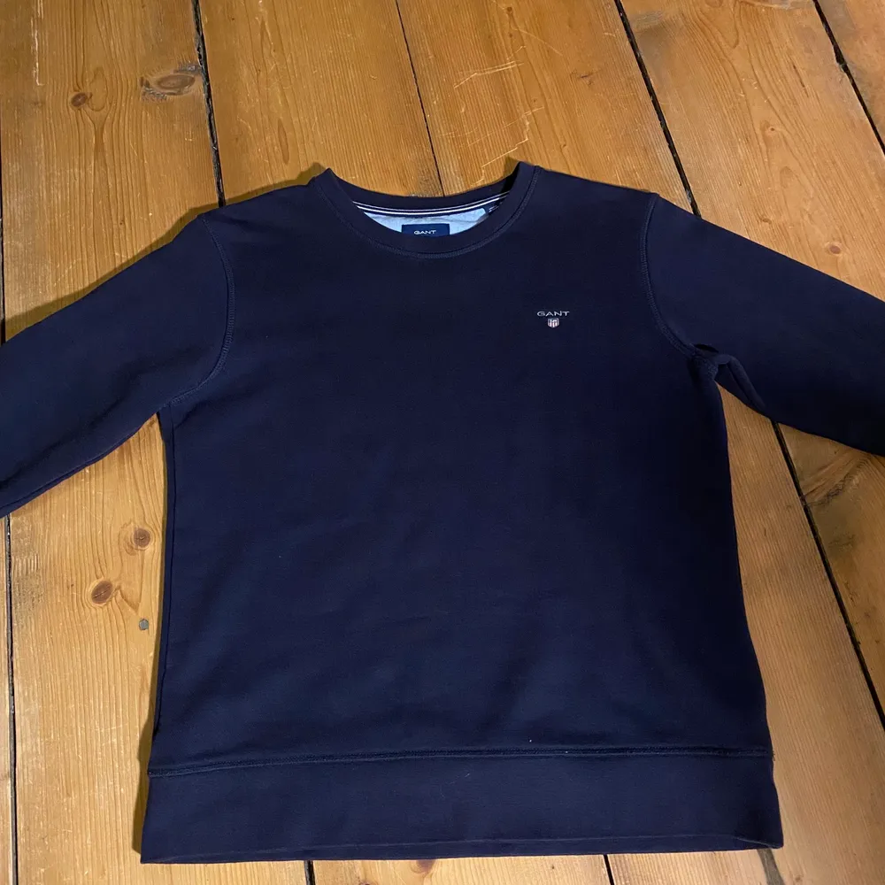 En marinblå/svart sweatshirt från märket GANT. I ett näst intill nyskick. Den är i storlek 170 cm (barnstorlek) eller 15 år. Sitter ungefär som XS/S. Pris + frakt (49kr).. Tröjor & Koftor.