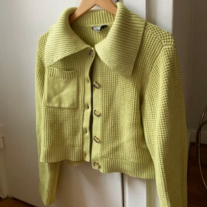 Virkad kofta - Grön virkad kofta med fina knappar. Inköpt för cirka 2 månader sen och använd fåtal gånger. Nyskick. Nypris cirka 1000 kr.