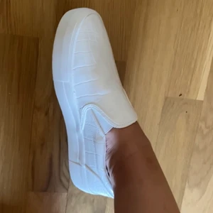 Vita skor NAKD - Fräscha vita skor från NAKD, slip in & krokodilmönster. I bra skick då de endast är använda några gånger💛 Storlek 40 men passar bra på mig som har 39! Nypris 429kr, säljer för 200kr + frakt🧡 HELT SLUTSÅLDA på hemsidan !!!