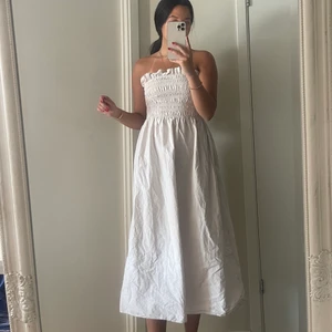 Långklänning - En supersöt vit/beige klänning i lite rysh på bröstet, går att ha med axelband eller utan. Skickar självklart med banden också men just nu är de utan. Aldrig använd utan endast testad 