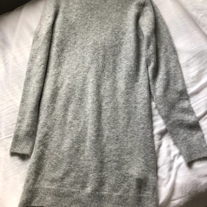 Stickad kläning  - Stickad grå klänning som är perfekt att ha med ett par höga boots. 