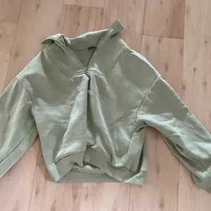 Grön sweatshirt med en liten zip 