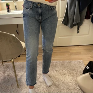 Jeans från Bik Bok - Jeans i en lite kallare blå färg, lågmidjade till medelhög midja, även slitna detaljer längst ner samt på ena bakfickan. Storlek small